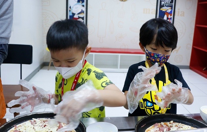 Pengunjung anak-anak di KidZania Surabaya saat memainkan peran atau profesi layaknya orang dewasa. KidZania Surabaya merupakan tempat wisata yang memiliki konsep edutainment theme park.